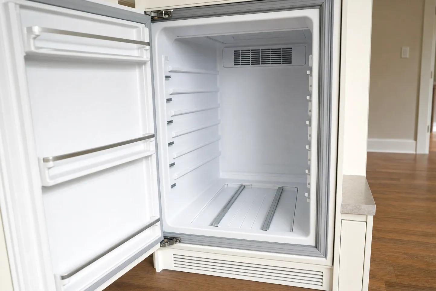Undercounter cabinet open to show the gray door gasket right round the opening and a louvred intake grille across the toe kick